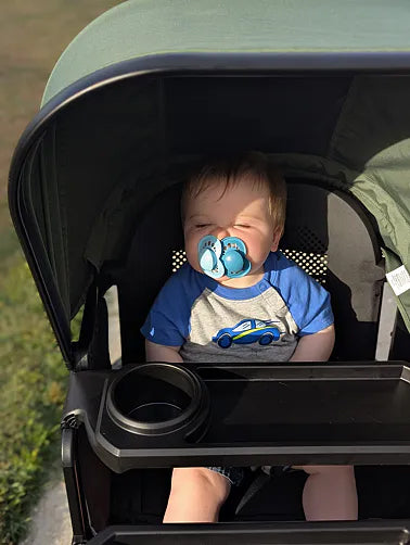 Smiling baby leaning forward in the Waggle seat