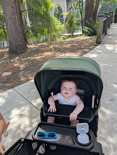 Toddler resting under the green Waggle canopy
