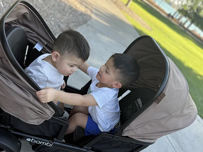 Two boys smiling at each other in their brown Waggle wagon