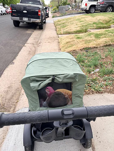 Parent’s view while pushing a toddler in a green Waggle wagon