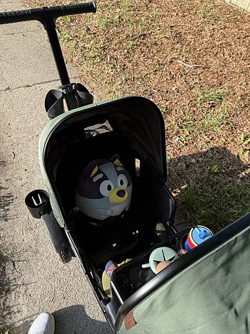 Green Waggle wagon carrying a Bluey pillow, drinks, and children’s belongings