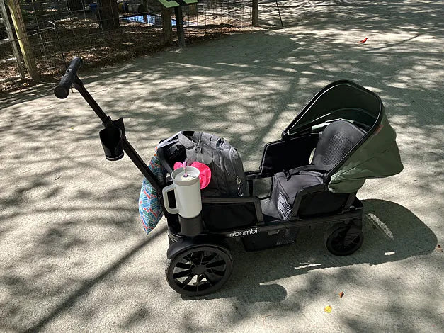 Packed green Waggle wagon parked on a shaded path at an outdoor venue